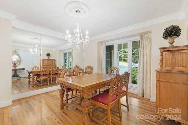 dining room with a healthy amount of sunlight, light hardwood / wood-style floors, a notable chandelier, and ornamental molding