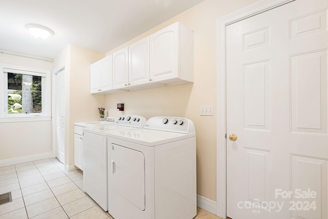 laundry area featuring light tile patterned flooring, separate washer and dryer, and cabinets