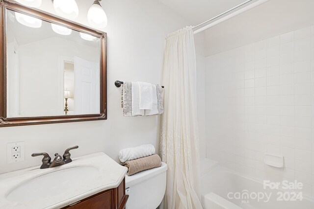 full bathroom featuring shower / bath combo with shower curtain, vanity, and toilet