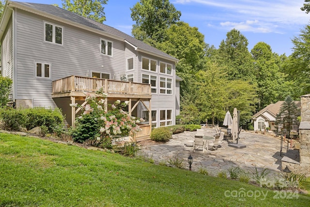 back of property with a patio, a deck, and a yard