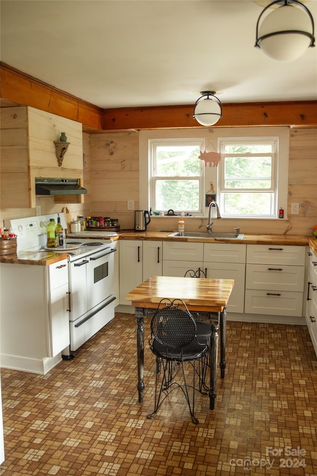 kitchen featuring white electric range, sink, plenty of natural light, and white cabinetry