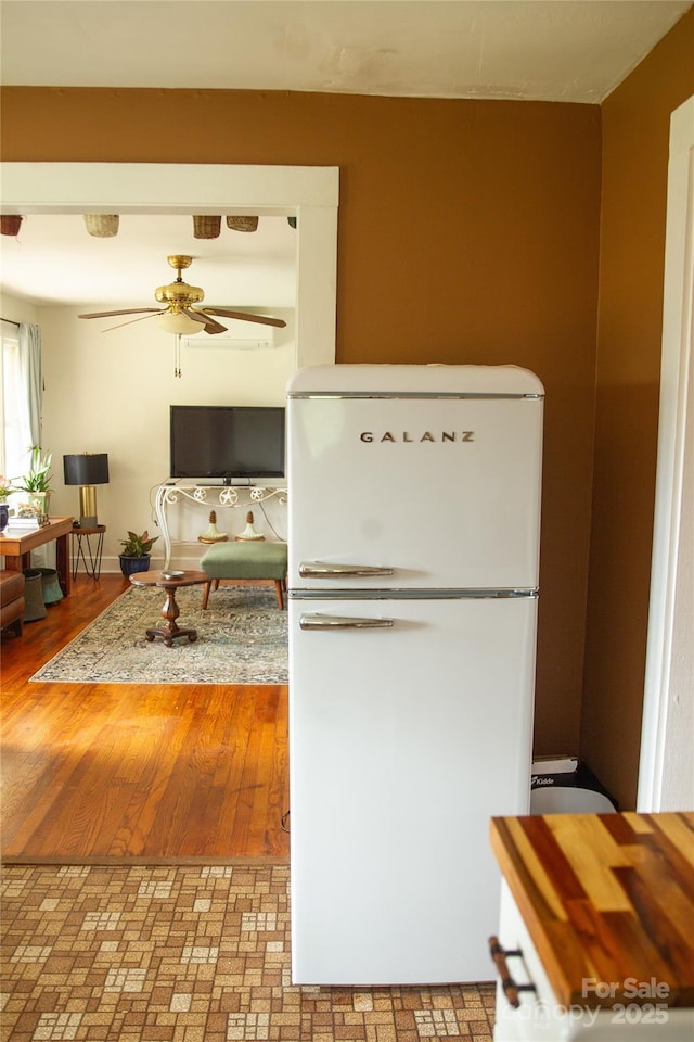 kitchen featuring ceiling fan, wood finished floors, and freestanding refrigerator