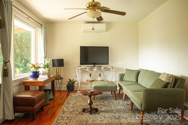 living area featuring a wall unit AC, a ceiling fan, baseboards, and dark wood-style flooring