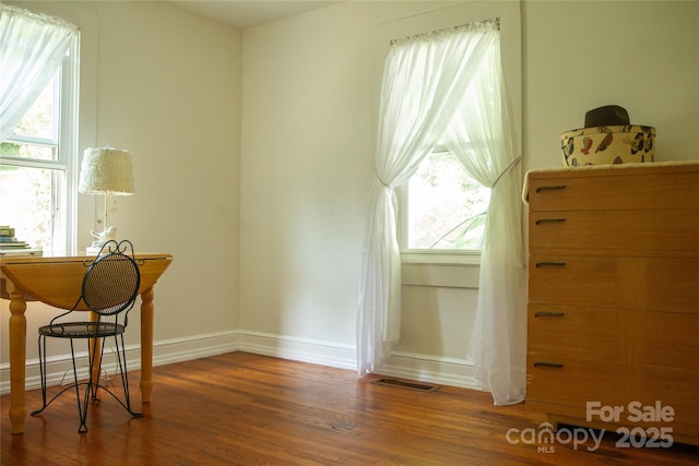 interior space with visible vents, baseboards, and wood finished floors