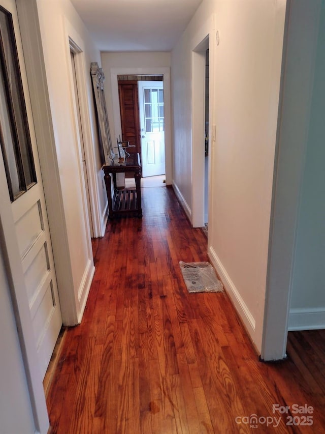 hallway with dark wood-style floors and baseboards