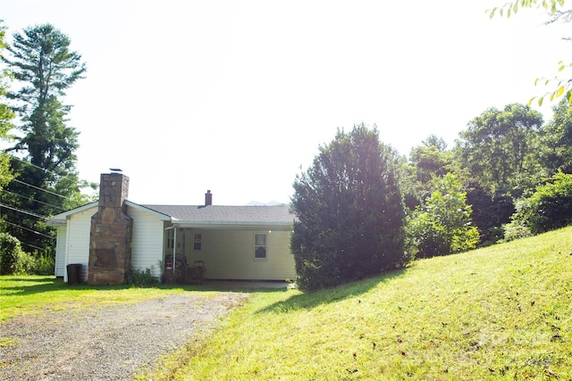 exterior space with a chimney and a lawn