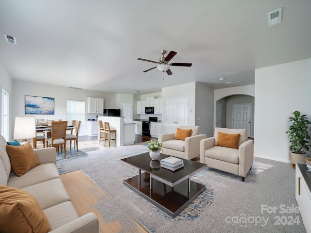 living room with ceiling fan and light wood-type flooring