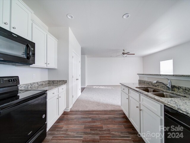 kitchen featuring light stone counters, ceiling fan, black appliances, dark carpet, and sink