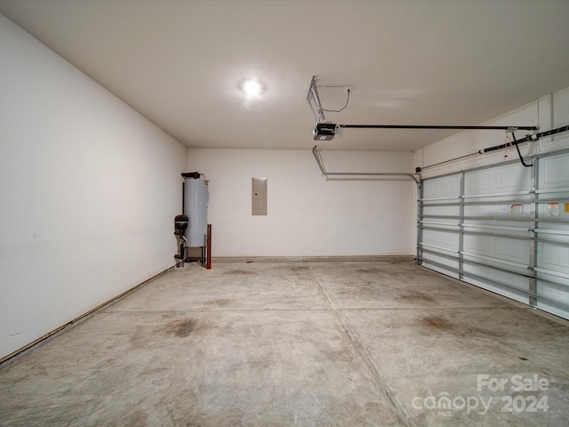 garage with electric panel, a garage door opener, and electric water heater