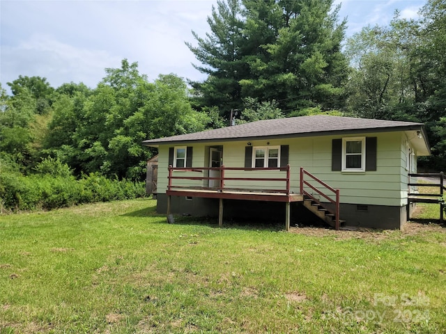 back of house featuring a deck and a lawn