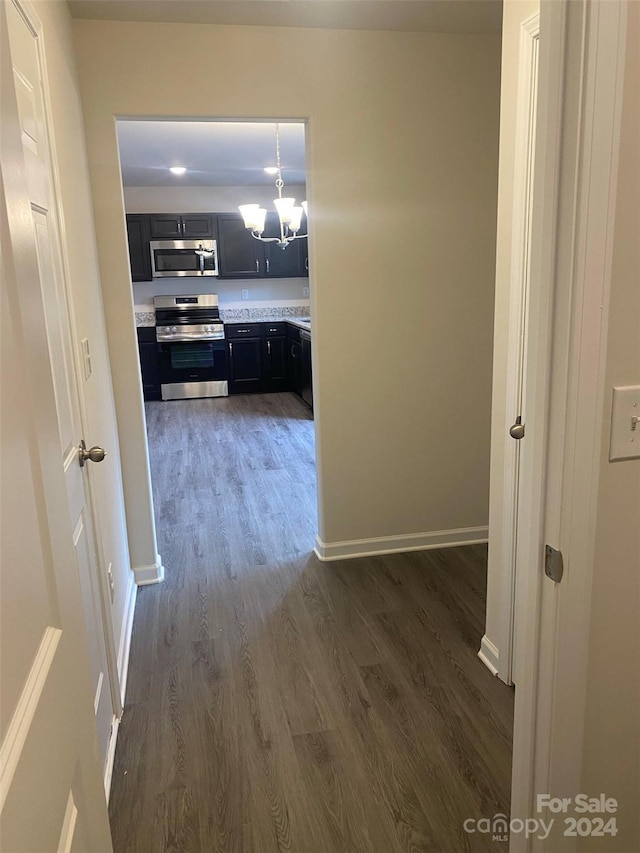 hall featuring dark hardwood / wood-style flooring and an inviting chandelier