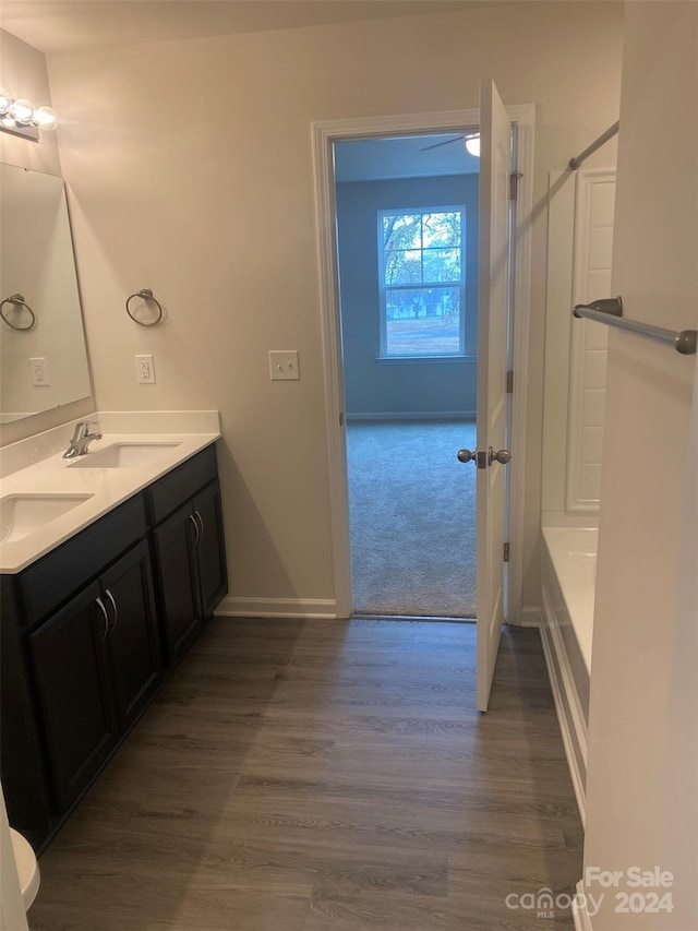 bathroom with hardwood / wood-style floors, vanity, and walk in shower