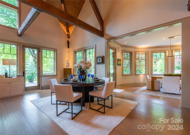 dining room featuring light hardwood / wood-style floors, beamed ceiling, and plenty of natural light