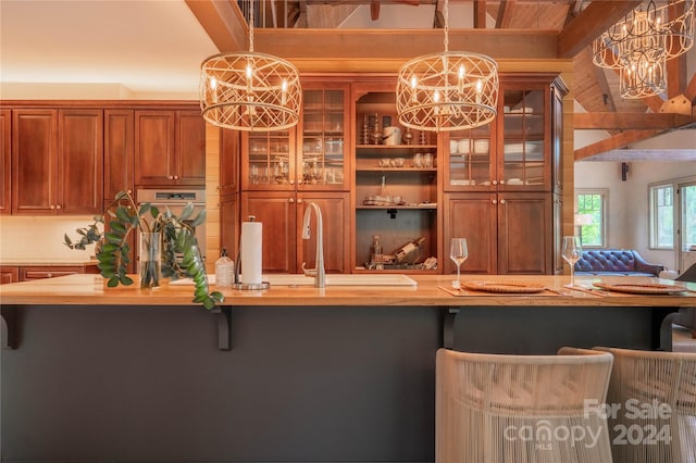 interior space with decorative backsplash, a kitchen breakfast bar, hanging light fixtures, and an inviting chandelier