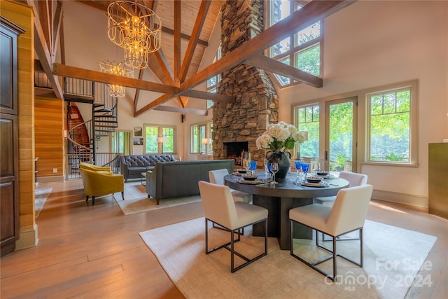 dining space with beamed ceiling, light hardwood / wood-style flooring, high vaulted ceiling, wooden ceiling, and a notable chandelier