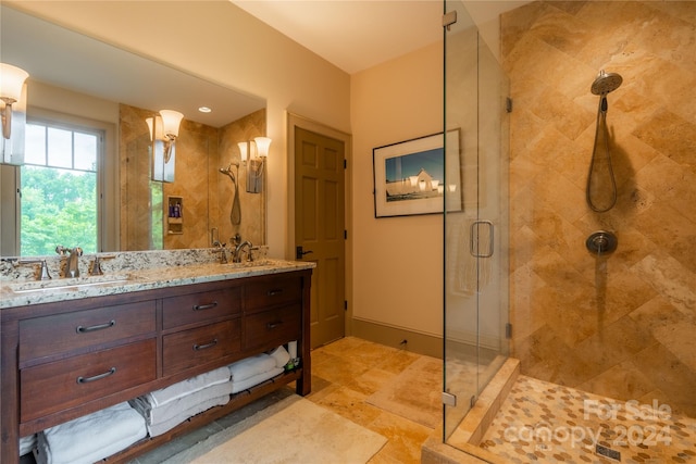 bathroom featuring tile patterned floors, a shower with door, and dual bowl vanity