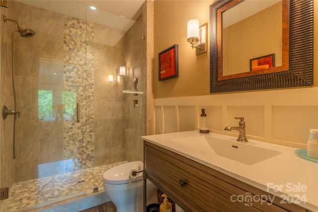 bathroom with tiled shower, toilet, and vanity