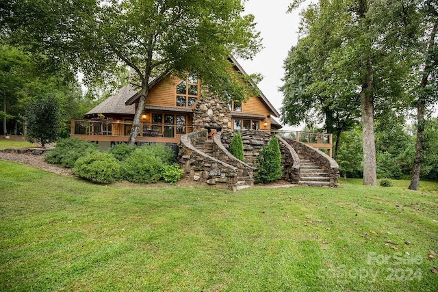 back of house with a deck and a lawn