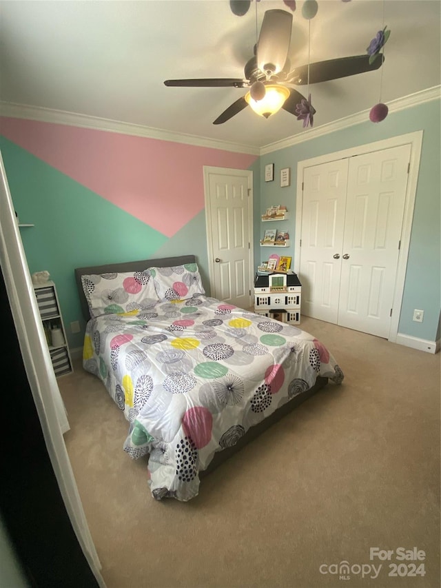 carpeted bedroom featuring a closet, ceiling fan, and crown molding