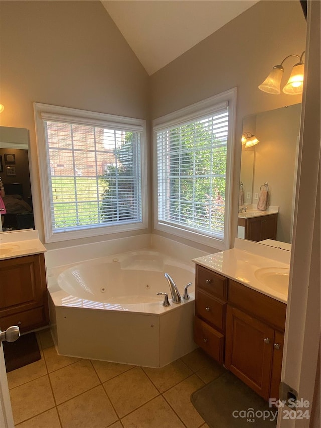 bathroom featuring vanity, a wealth of natural light, tile patterned flooring, and vaulted ceiling