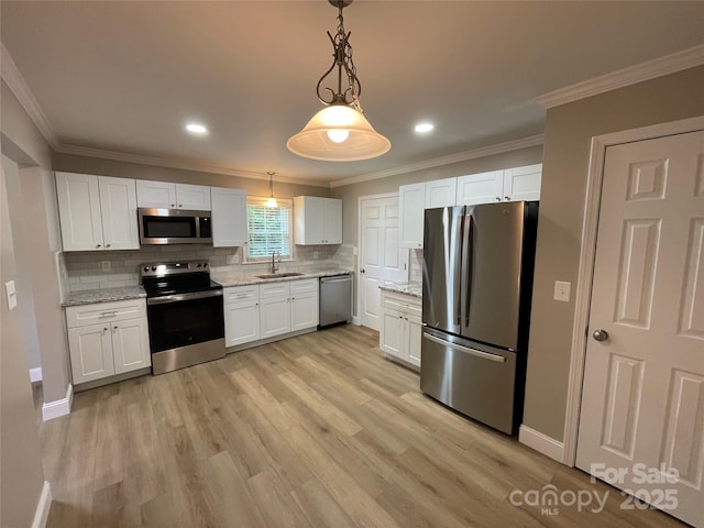 kitchen with white cabinetry, decorative light fixtures, light wood-type flooring, appliances with stainless steel finishes, and light stone countertops