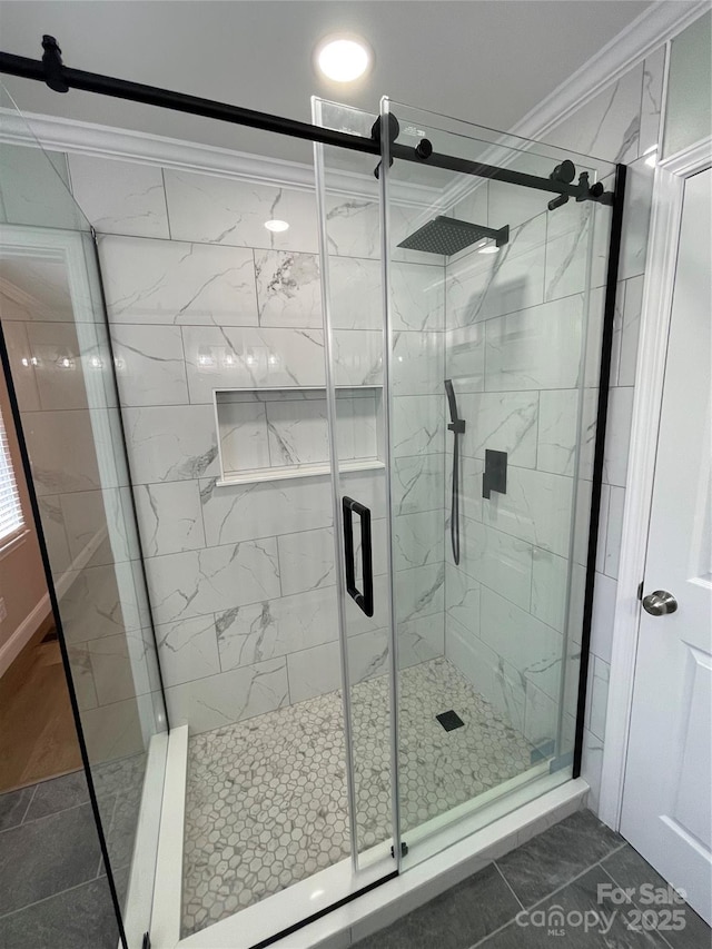 bathroom featuring a shower with shower door and ornamental molding