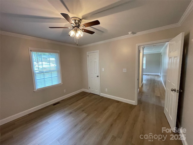 unfurnished bedroom featuring hardwood / wood-style flooring, ornamental molding, and ceiling fan