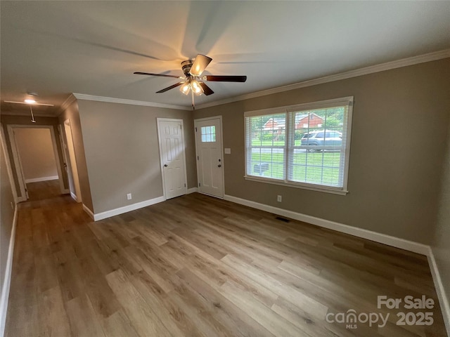 foyer featuring wood-type flooring, ornamental molding, and ceiling fan