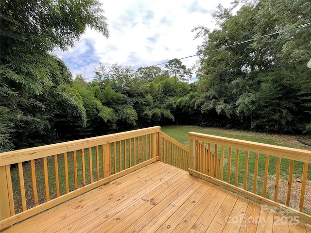 wooden deck featuring a lawn