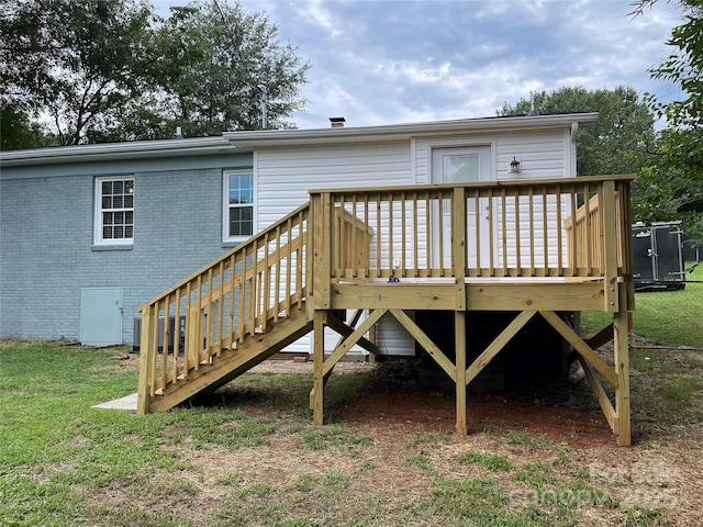 back of property featuring a wooden deck and a yard