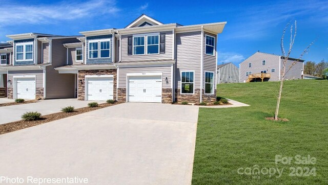 view of front of property featuring a garage and a front lawn