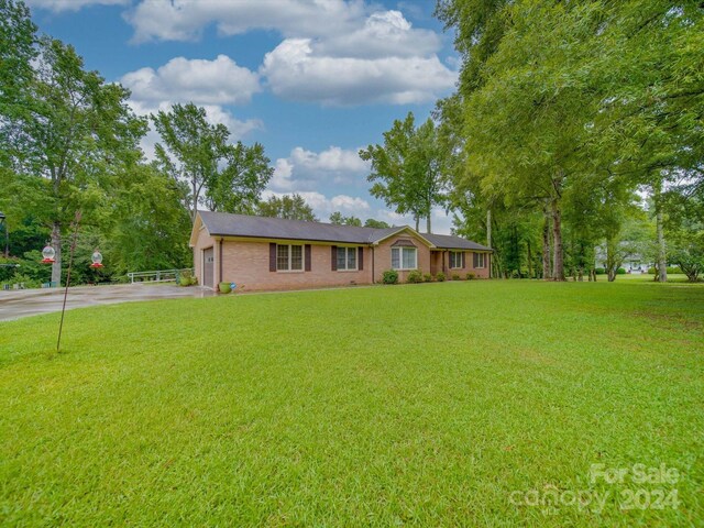 single story home with a garage and a front lawn