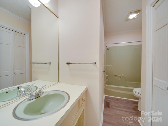 full bathroom with washtub / shower combination, toilet, ornamental molding, vanity, and hardwood / wood-style floors