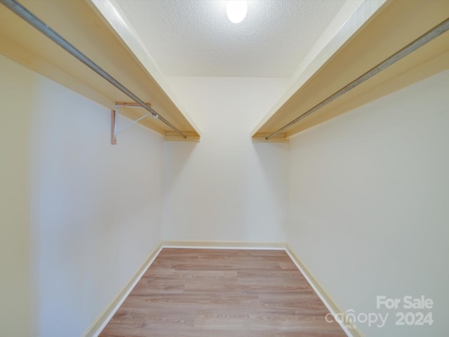 walk in closet with light hardwood / wood-style floors