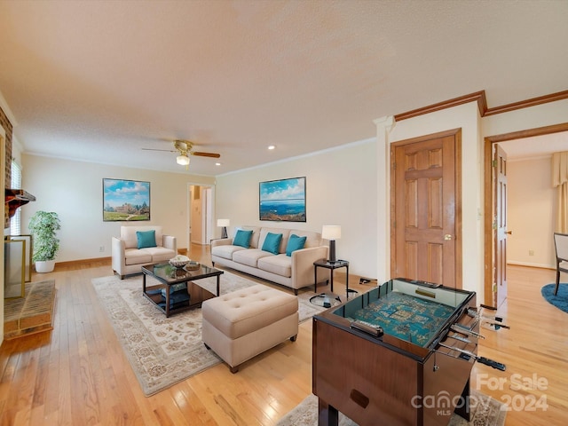 living room featuring ceiling fan, ornamental molding, and light hardwood / wood-style flooring