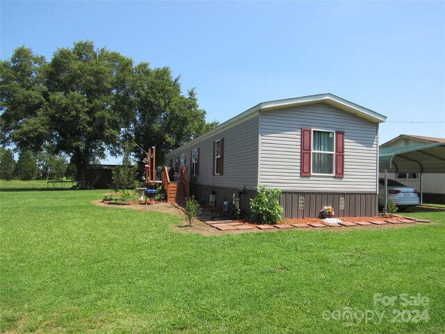 view of home's exterior featuring a carport and a yard