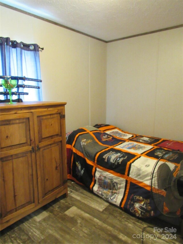 bedroom featuring dark wood-type flooring and a textured ceiling