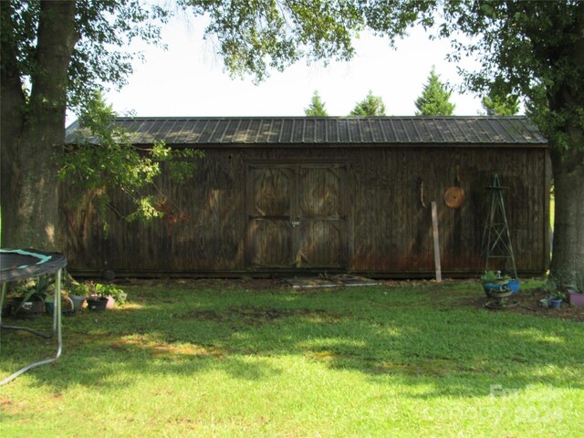 view of yard featuring an outbuilding and a trampoline