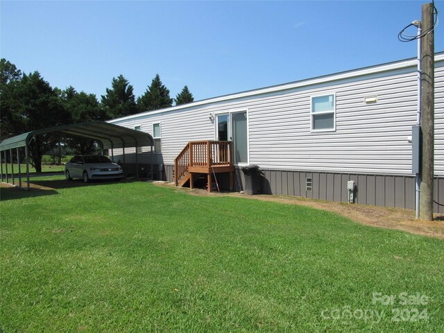 rear view of house featuring a carport and a lawn