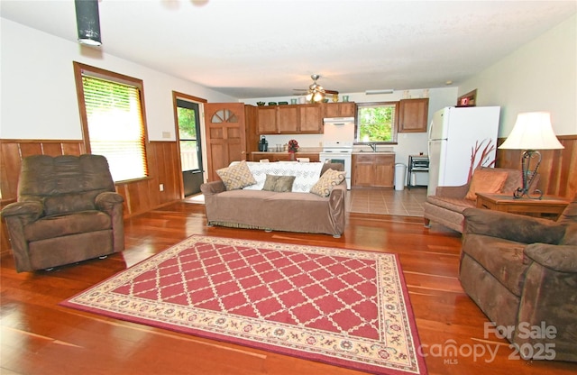 living room featuring a wealth of natural light, dark hardwood / wood-style flooring, and ceiling fan