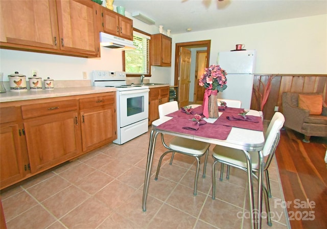 kitchen with light tile patterned flooring, white appliances, and sink