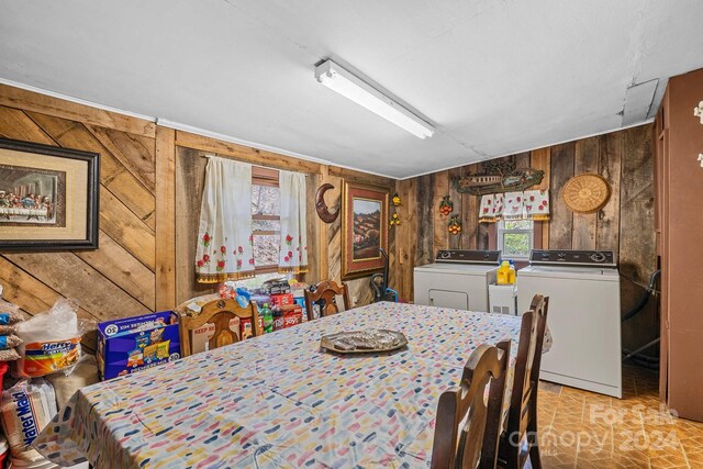 dining space with separate washer and dryer and wooden walls