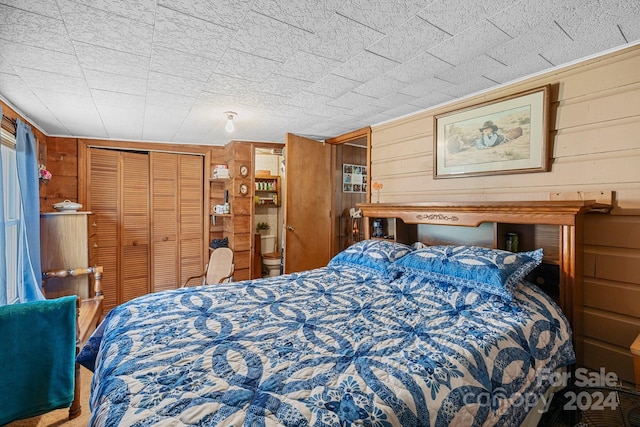 bedroom featuring wood walls and a closet