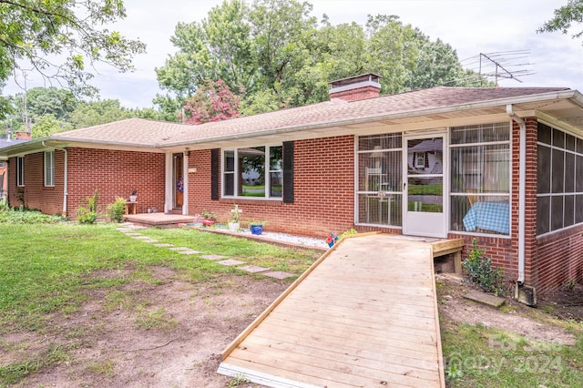 view of front of property with a front yard and a sunroom