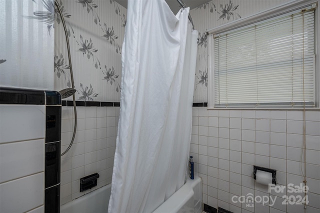 bathroom featuring tile walls and shower / tub combo