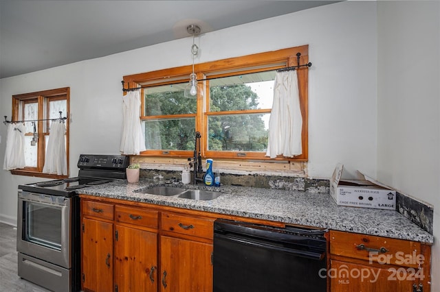 kitchen featuring black dishwasher, sink, stainless steel range with electric stovetop, hanging light fixtures, and light stone countertops