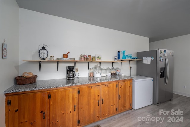 kitchen featuring stainless steel fridge, refrigerator, and light hardwood / wood-style flooring