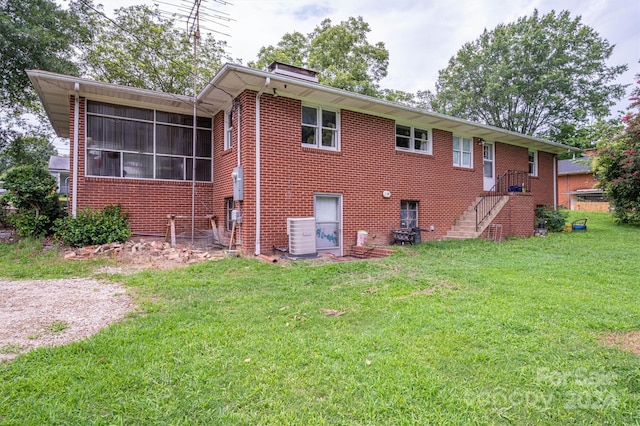 back of property with a lawn, a sunroom, and central air condition unit