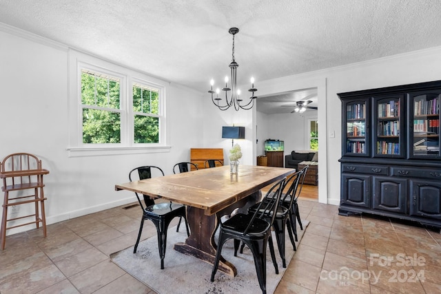 tiled dining room with ornamental molding, a healthy amount of sunlight, and a textured ceiling