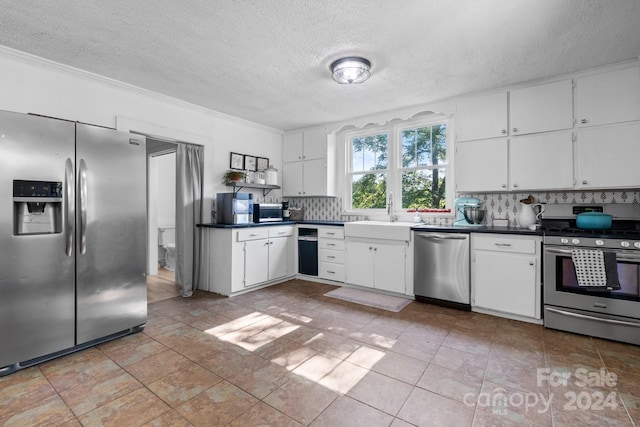 kitchen with tasteful backsplash, white cabinetry, sink, stainless steel appliances, and a textured ceiling